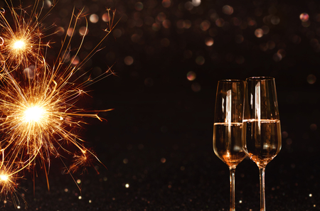 Festive background with sparkling miracle candle and champagne for new years eveの写真素材