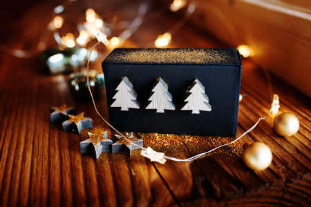 Christmas still life with a gift box and star lights on a rustic wooden tableの写真素材
