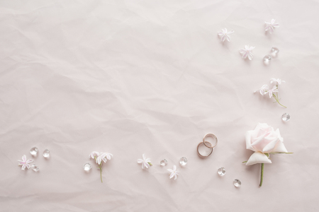 Wedding rings on pink background with rose pedalsの写真素材