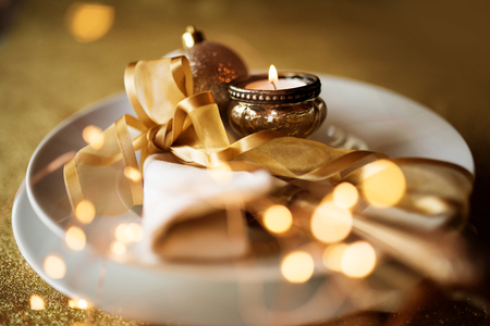 Festive christmas table decoration with golden bokehの写真素材