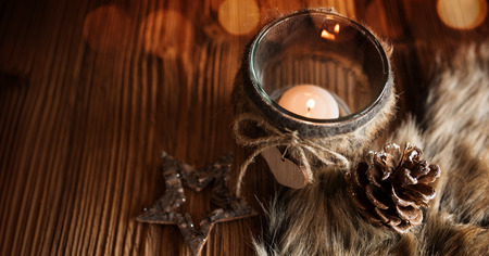 Christmas still life in country house style with a cuddly fleece on a rustic wooden table and festive bokehの写真素材