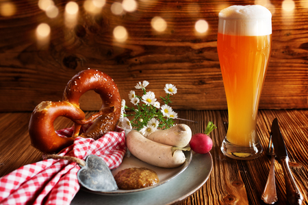 Oktoberfest traditional with wheat beer pretzel and white sausage on rustic woodの写真素材