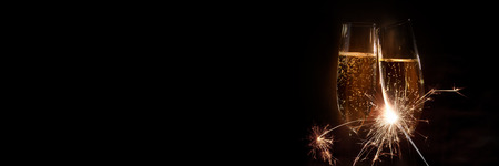 Cheers with champagne and sparkler on black backgroundの写真素材