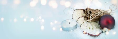 Christmas still life in cold winter with burning candle and bokehの写真素材