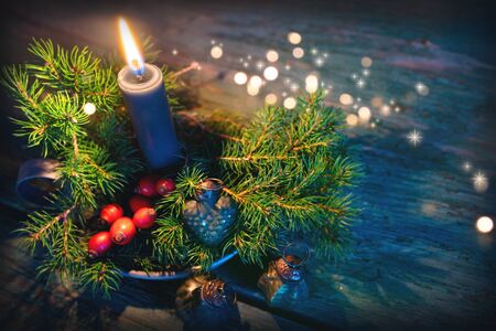 Candle with christmas ornaments and festive golden bokehの写真素材