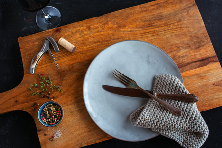 Rustic place setting on wooden cutting board. Background for a gastronomy concept or a barbeque...