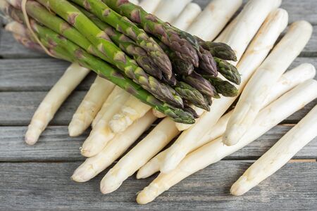 Green and white asparagus on rustic gray wooden planks. Close-up of vegetables for a healthy nutrition concept.の写真素材