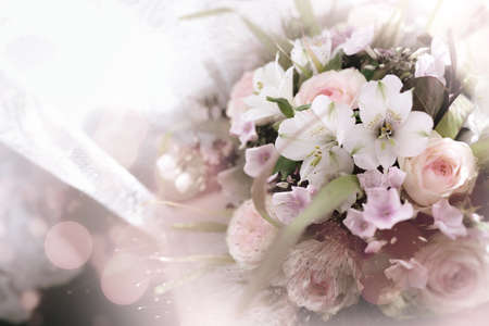 Beautiful bridal bouquet for a wedding. Tender roses on white vintage background with bokeh effects. Close up with short depth of field and space for text.の写真素材