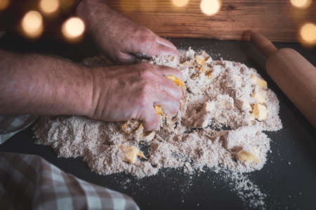 Dough preparation with flour, butter and egg for homemade christmas cookies. Concept for baking at home with fresh ingredients and golden bokeh.の写真素材
