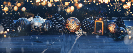 Christmas decoration on a wooden table in darkness with golden bokeh and snowflakes. Background for...