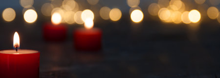 Christmas candle light with blurred golden bokeh for religious ritual and funeral service or spiritual meditation. Background for peaceful mind and soul with space for text.の写真素材