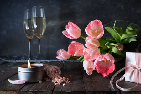 Atmospheric mothers day decoration with bouquet of pink tulips and gift on dark vintage wood.の写真素材