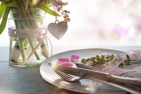 Table decoration for a mothers day menu. Spring flowers with heart shape on gray wooden table and...