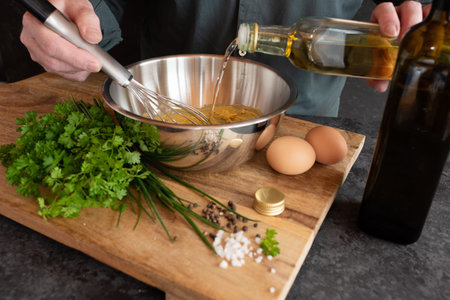 Preparing a gribiche sauce for green asparagus. Hands prepare fresh ingredients for a tasty side...