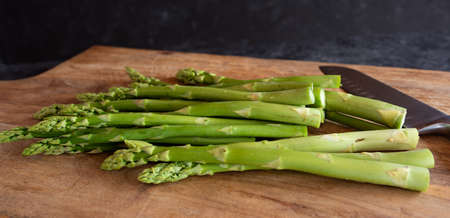 Green asparagus on a wooden cutting board. Vegetable for a healthy eating concept. Gastronomy and lifestyle background. Close-up.の写真素材