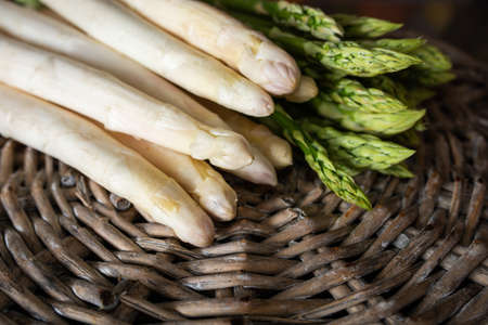 Fresh white and green asparagus on rustic wooden wickerwork. Healthy vegetables. Food photography with short depth of field. Background for seasonal gastronomy.の写真素材