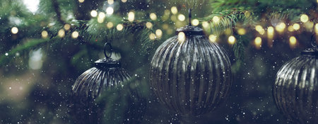 Old silver christmas baubles at fir tree with golden lights and snowflakes. Horizontal background with short depth of field for Chritmas time. Close-up.の写真素材