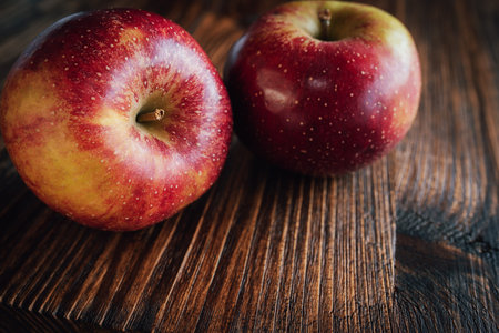 Red winter apple ondark wood. Close up from seasonal fruits. Background for healthy nutrion with...