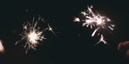 Sparklers on dark night sky. Bengal fire for christmas background with space for text.