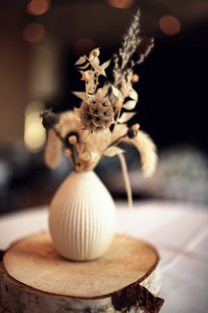 Beautiful dried flower bouquet in natural boho style with atmospheric bokeh. Sustainable decoration for weddings and holidays. Vertical floral still life with focus on a blossom. Short depth of field.の写真素材