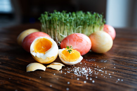 Easter eggs garnished with fresh healthy cress sprouts and salt. Close-up on rustic wooden table and short depth of field.の写真素材