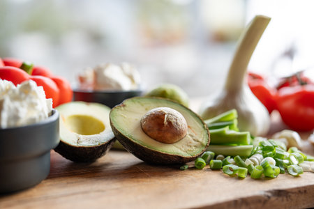 Fresh vegetables and healthy ingredients on a wooden cutting board in front of bright kitchen window. Healthy nutrition concept for a fitness diet. Close up.の写真素材