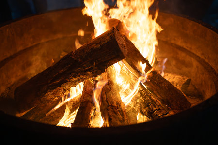 Blazing wood fire burning in a fire pit. Close-up of a warming campfire. Horizontal background for leisure and adventure.の写真素材