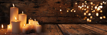 Christmas greeting card white burning candles on old dark wood and golden bokeh. Christmas background with warm glow and dimly lit environment.の写真素材