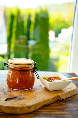Fresh Mexican homemade salsa sauce in a mason jar. Spicy sauce with tomatoes and roasted vegetables....