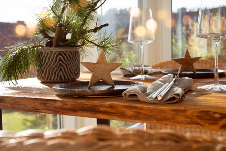 Atmospheric Christmas table decoration in a cozy conservatory with festive bokeh lights. Decorations concept for a Christmas dinner in restaurant.の写真素材