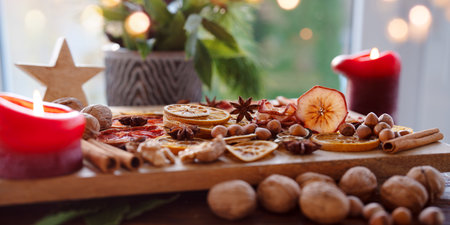 Dried citrus fruits and apple rings with nuts on rustic wood. Background for Christmas preparations and decorations.の写真素材