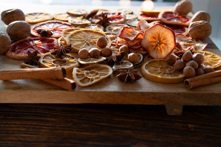 Dried citrus fruits and apple rings with nuts on rustic wood for Christmas. Preparations for Christmas baking and hot drinks.の写真素材