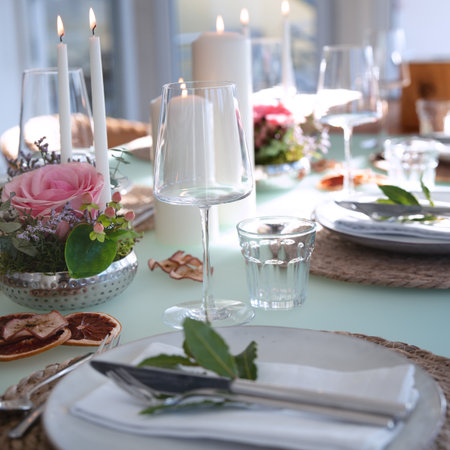 A festively set table for a wedding dinner. Tastefully decorated restaurant background with short depth of field.の写真素材