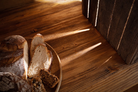 Various types of homemade bread presented on rustic wood. Diverse range of healthy backed food in...