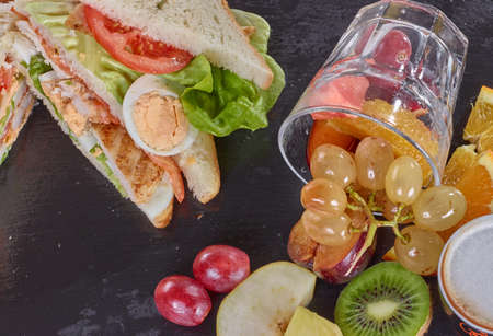 Snack food with chicken meat grapes kiwi, egg and breadの写真素材