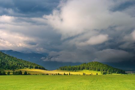 Green field and storm cloudsの写真素材