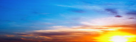 Cloudscape with blue sky and rising sun