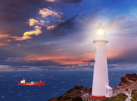 Sunset seascape, lighthouse on the bluffの写真素材