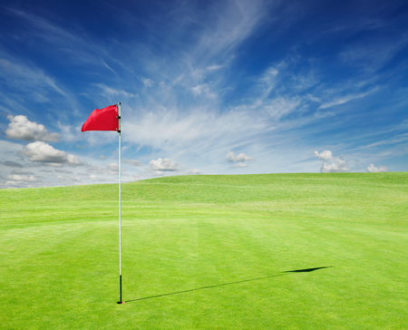 Golf field with red flag in the holeの写真素材