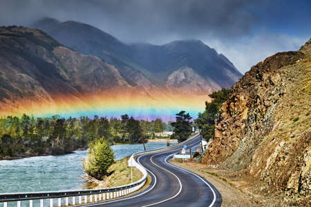 The Chuysky Trakt one of the most beautiful mountain roads of the world, Chuya river and rainbow over roadの写真素材