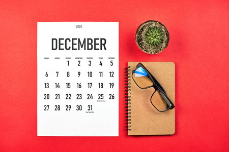 Simple December calendar at stylish red colored office deskの写真素材