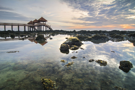 the rocky beach and mossy at jetty Tanjung Balau on cloudy sunriseの写真素材