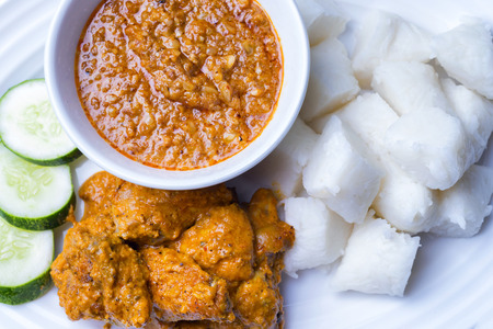 Chicken Rendang is popular dishes in Malaysia, with onion, peanut and lemongrass as decoration on wooden tableの写真素材