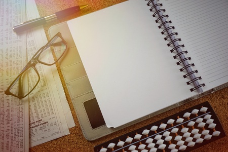 Notebook, newspapers, pen, glasses and abacus on a wooden table, view from above. Financial conceptの写真素材