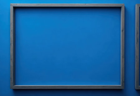 blank picture frame on blue wall with copy space for text or imageの写真素材