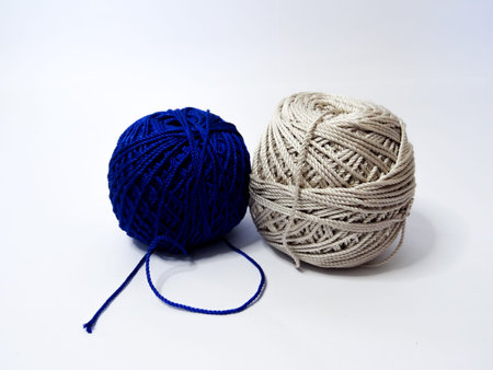 knitting yarn in brown, blue and white colors on a white background