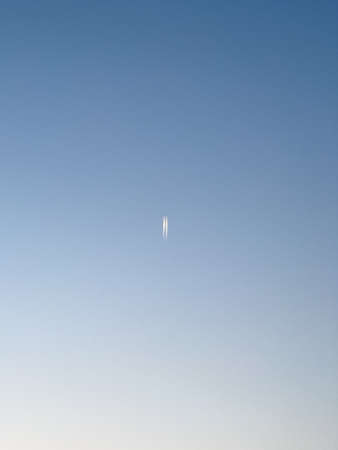A vertical shot of a blue sky with a white object in the airの写真素材