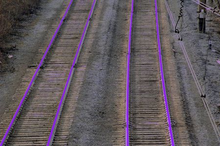Railroad with rails tinted in acid ultra-violet colorの写真素材