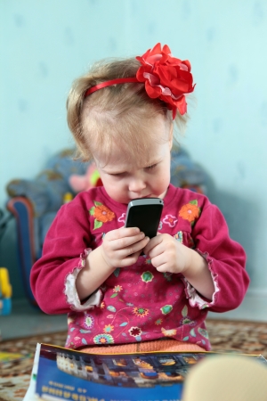 Little girl playing with phoneの写真素材