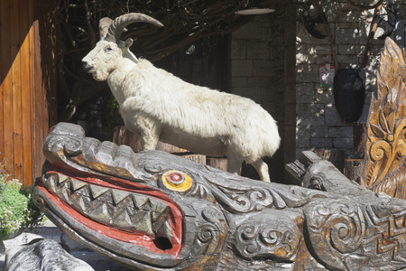 Sculptural composition of a stuffed goat and carved wooden crocodile at the foot of the tower on a mountain Big Ahun, Sochi, Krasnodar region, Russiaのeditorial素材
